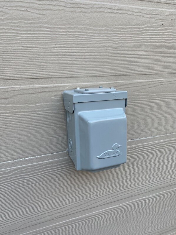 A grey electrical box with a bird emblem on a textured wall. - Family Friendly Mountain Getaway with Theater & Arcade in the Laurel Highlands (Somerset)