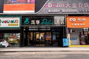 A storefront with a sign for 'Dragon Palace Deluxe Hotel' and adjacent shops. - Longxiang Deluxe Hotel (Fangchenggang Administration Center) (Fangchenggang)