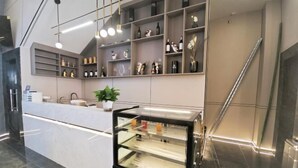 A modern reception area with a glass display case, a reception desk, and shelves with various items.