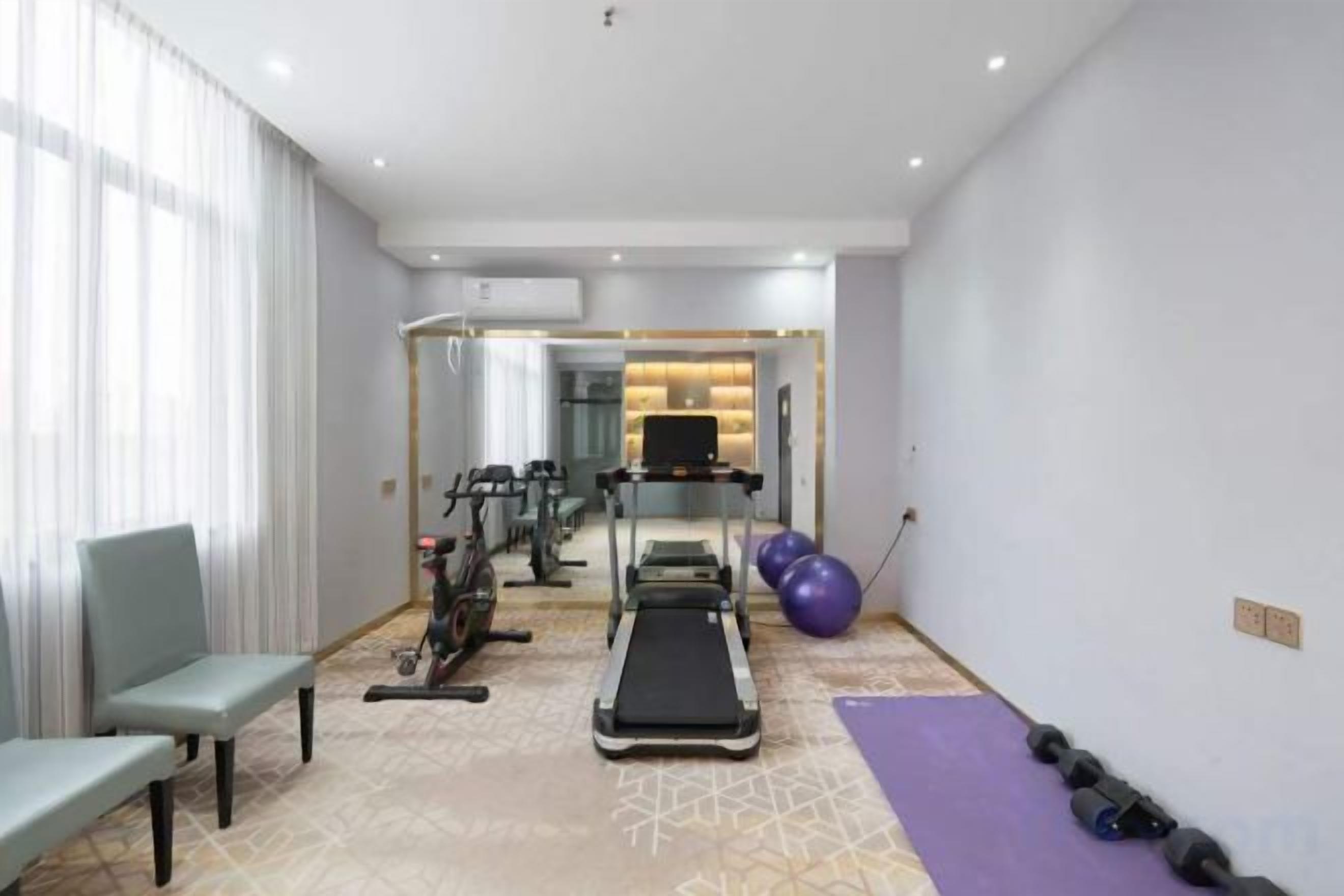 A fitness room with a treadmill, exercise bike, and free weights.