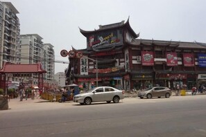 A street with traditional architecture, including a building with a pagoda-style roof and multiple signs. - 100 Inn (Small Shanghai pedestrian street) (Shanghai)