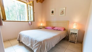 A bedroom with a bed, two bedside tables, a nightstand, a window, and two wall-mounted pictures. - Les Genêts - LIT-ET-MIXE (LIT-ET-MIXE)