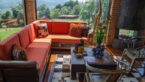 Un rincón acogedor con un sofá, una mesa de centro de madera y vistas al exterior.
