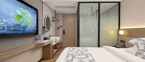 A modern hotel room with a large bed, a flat-screen TV, a bathroom with a mirror, and a sliding door closet.