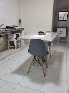 A modern kitchen with a dining table, chairs, a microwave, and a sink. - Temporary apartment (Corrientes)