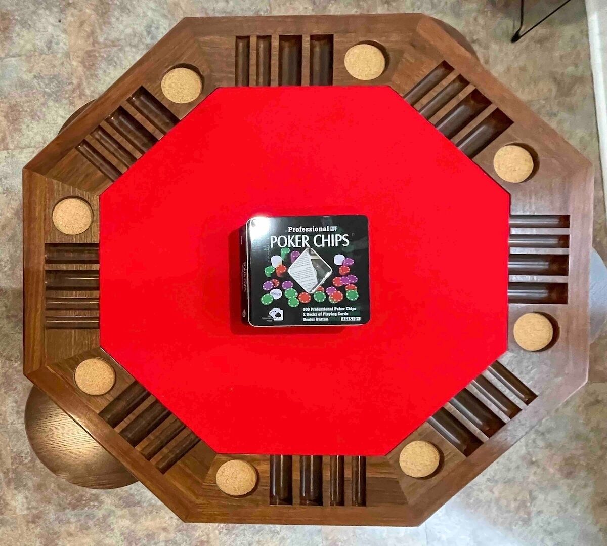 A poker chip box on a red octagonal table with eight slots.