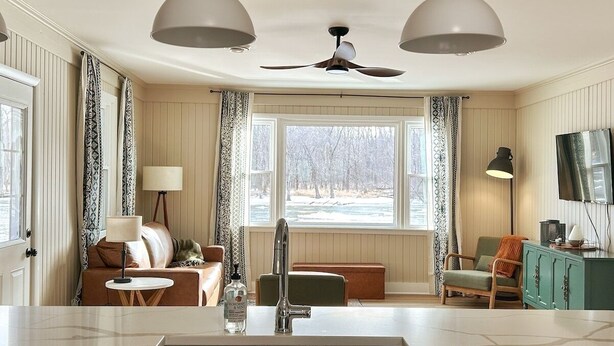 A modern kitchen with a central island, a built-in sink, and pendant lighting. - Escape to The Riverfront Hideaway (Momence)