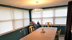 A dining area with a table, chairs, and a chandelier.
