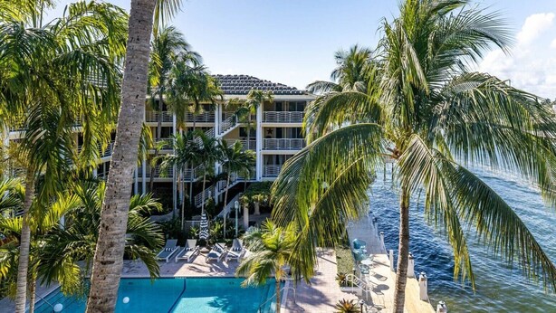 A hotel with a pool, palm trees, and a view of the ocean. - Top Floor Corner Unit: 2BR Waterfront with Stunning Intracoastal Views (Boca Raton)