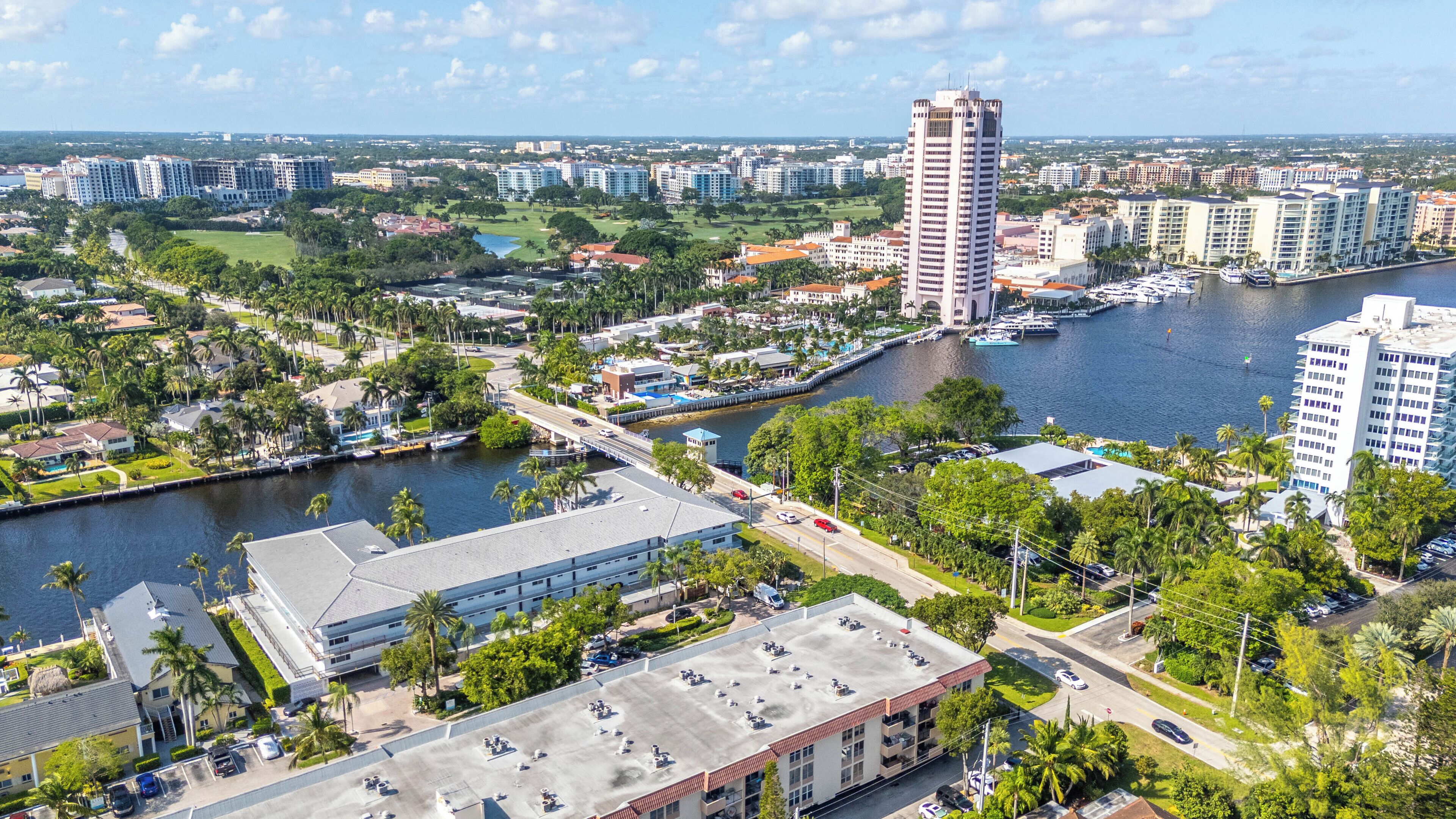 A coastal cityscape with a marina, high-rise buildings, and a mix of residential and commercial structures.