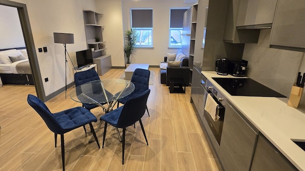 A modern apartment with a dining area, kitchen, and living space.