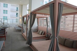 A modern hotel room with a large bed, a small table, and a seating area with a view of the city. - Chic Downtown Studio With Rooftop Pool and Gym (Miami)