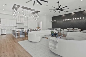 A modern kitchen with white cabinets, a central island, and pendant lighting. - 30A Salt & Solace Pool, Golf Cart, Hot Tub + Outdoor Kitchen (Santa Rosa Beach)