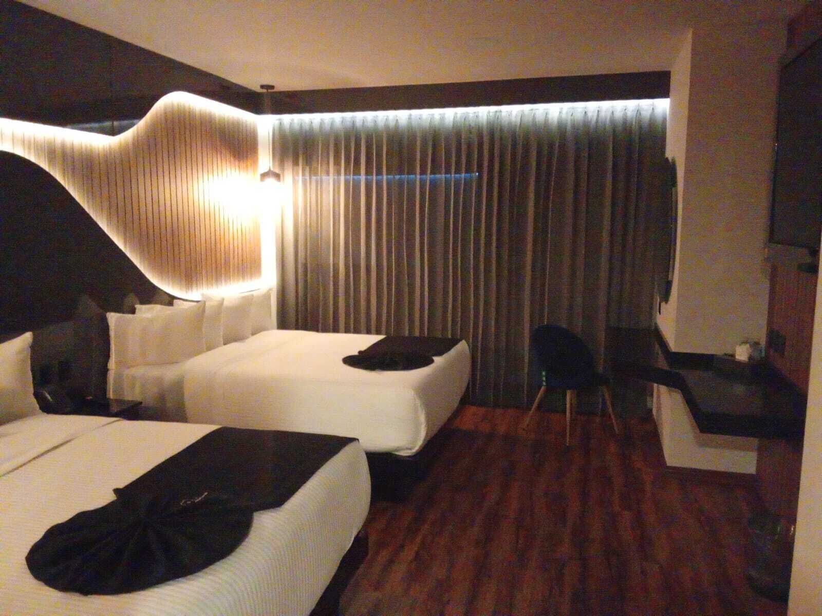 Habitación de hotel con dos camas, un escritorio y una silla.