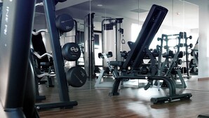 Una palestra con diverse attrezzature per esercizi, tra cui manubri e macchinari per pesi.