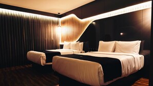 Una camera d'albergo con un letto grande, due comodini e una lampada moderna.