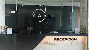 Una reception con un bancone in marmo e un cartello con scritto "YORU".
