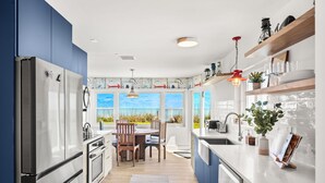 Una cocina moderna con un amplio ventanal, un comedor y un horno empotrado.