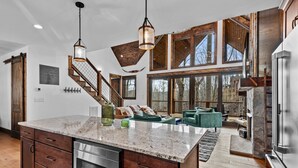 A spacious kitchen with a large island, wooden cabinets, and stainless steel appliances.