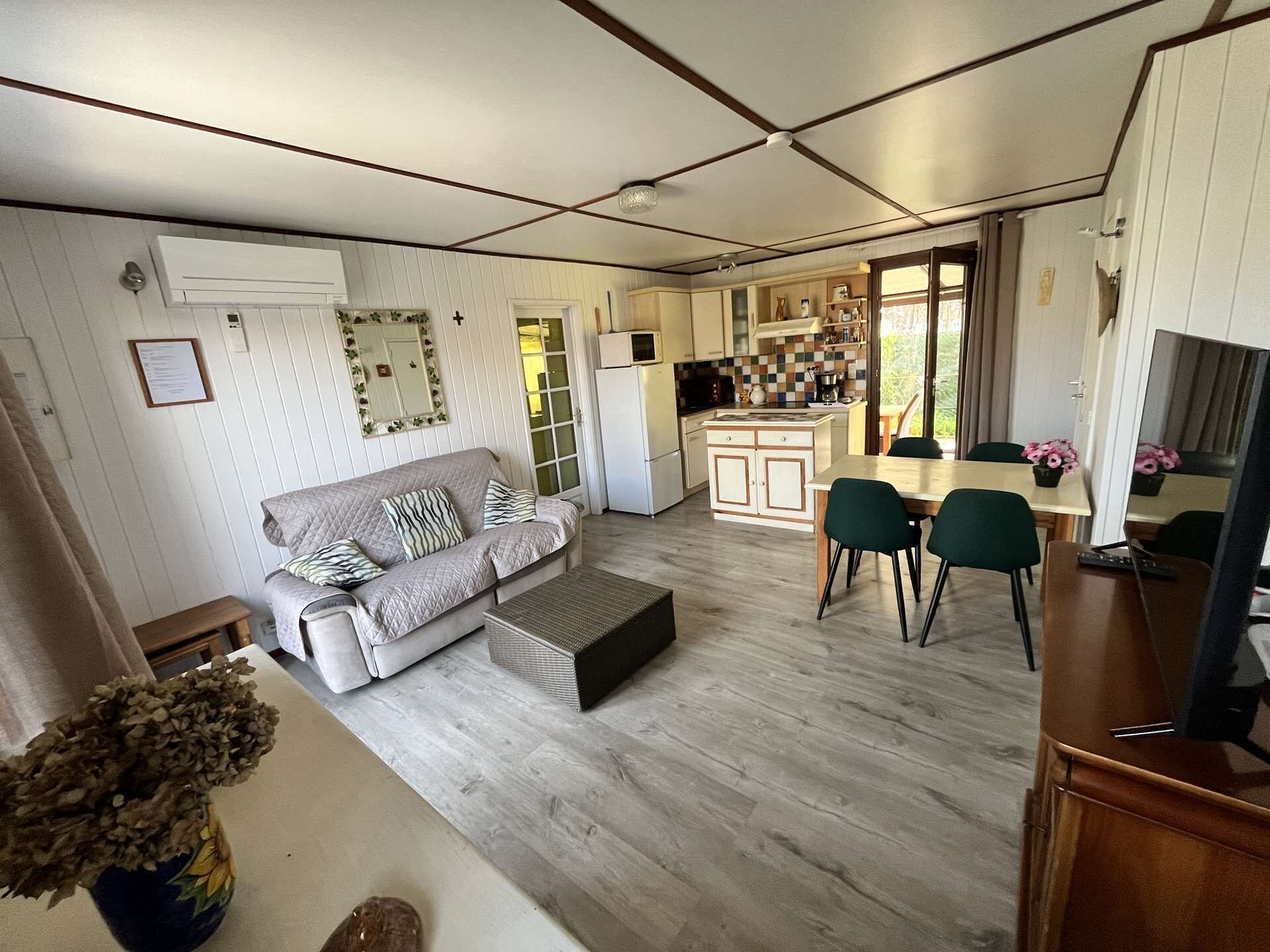 A compact living space with a sofa, a dining table, and a kitchenette.