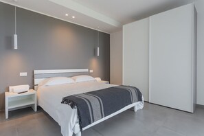 A modern bedroom with a bed, bedside tables, and a wardrobe.