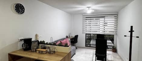A compact living space with a kitchenette, a dining area, and a seating area with a view.