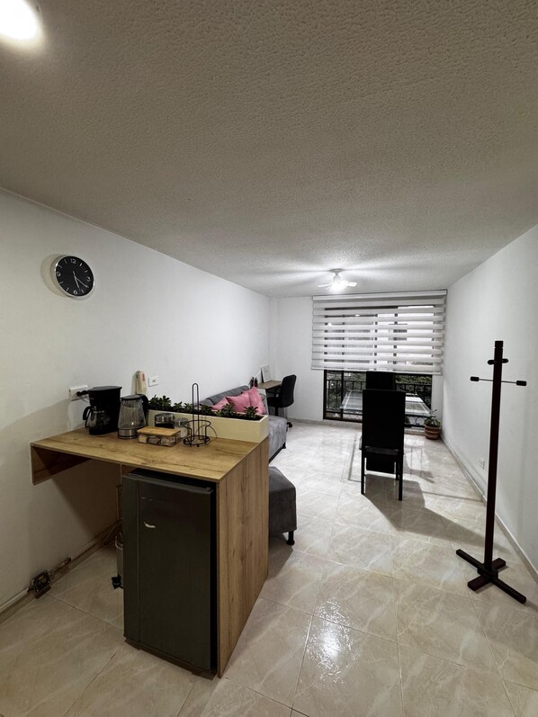 A compact living space with a kitchenette, a dining area, and a seating area with a view.