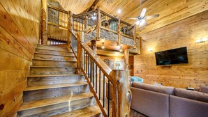 A wooden staircase with a wooden handrail and a ceiling fan.