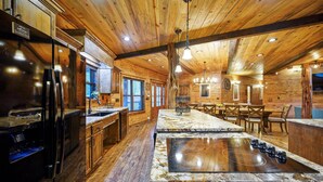 A spacious kitchen with wooden ceilings, a central island, and modern appliances.