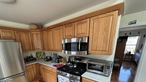 A kitchen with wooden cabinets, stainless steel appliances, and a window.