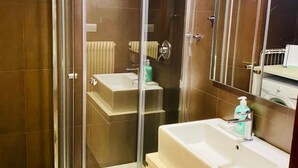 A modern bathroom with a glass-enclosed shower, a white sink, and a mirror above the sink. - SUITE300 - Apartment in the heart of Treviso (Treviso)