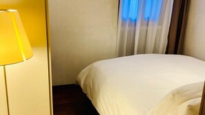 A hotel room with a bed, a lamp, and a window with curtains. - SUITE300 - Apartment in the heart of Treviso (Treviso)