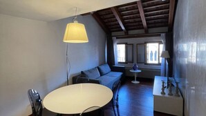 Une pièce chaleureuse avec une table ronde, un canapé et une lampe.