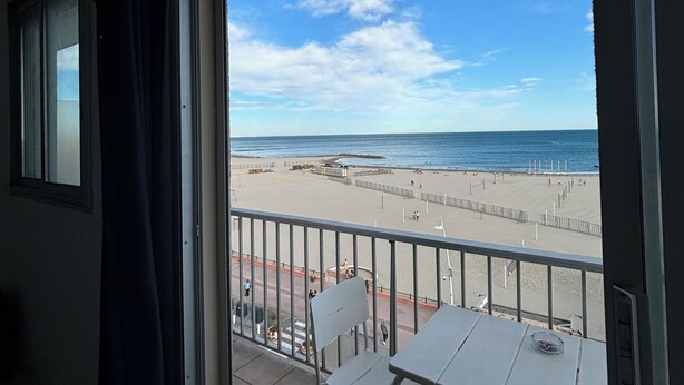 Ein Balkon mit Blick auf Strand und Meer.