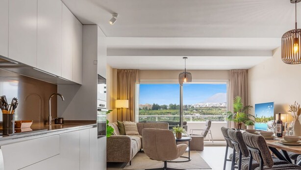A modern living room with a sofa, chairs, a dining table, and a view of a cityscape.