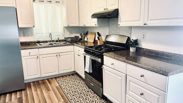 Full-sized fridge, microwave, stovetop, cookware/dishes/utensils