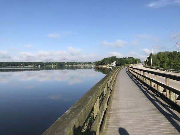 Un lac paisible, avec une promenade en bois qui s’avance sur l’eau.