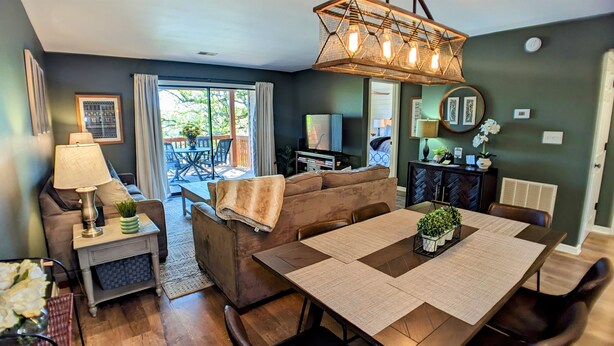 A cozy living room with a sofa, a dining table, and a TV.