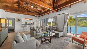 A spacious living room with a high ceiling, a dining area, and a view of the sea. - Magens Bay - dining - POOL - Incredible views (St. Thomas)