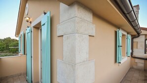 A corner of a building with a beige wall, a stone pillar, and turquoise shutters on doors. - Villa Casa Blu (Kvarner - Kras) (Kras)