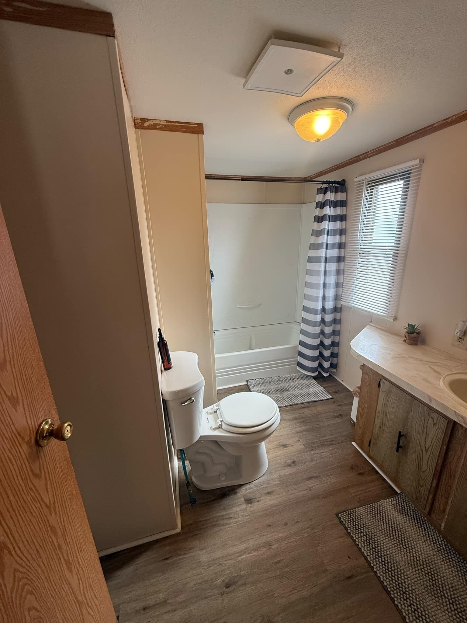 A compact bathroom with a toilet, shower, and sink.