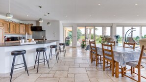 A spacious kitchen with a large island, bar stools, and a dining area with a table and chairs.