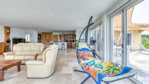 A spacious living area with a sofa, a coffee table, and a colorful hammock.