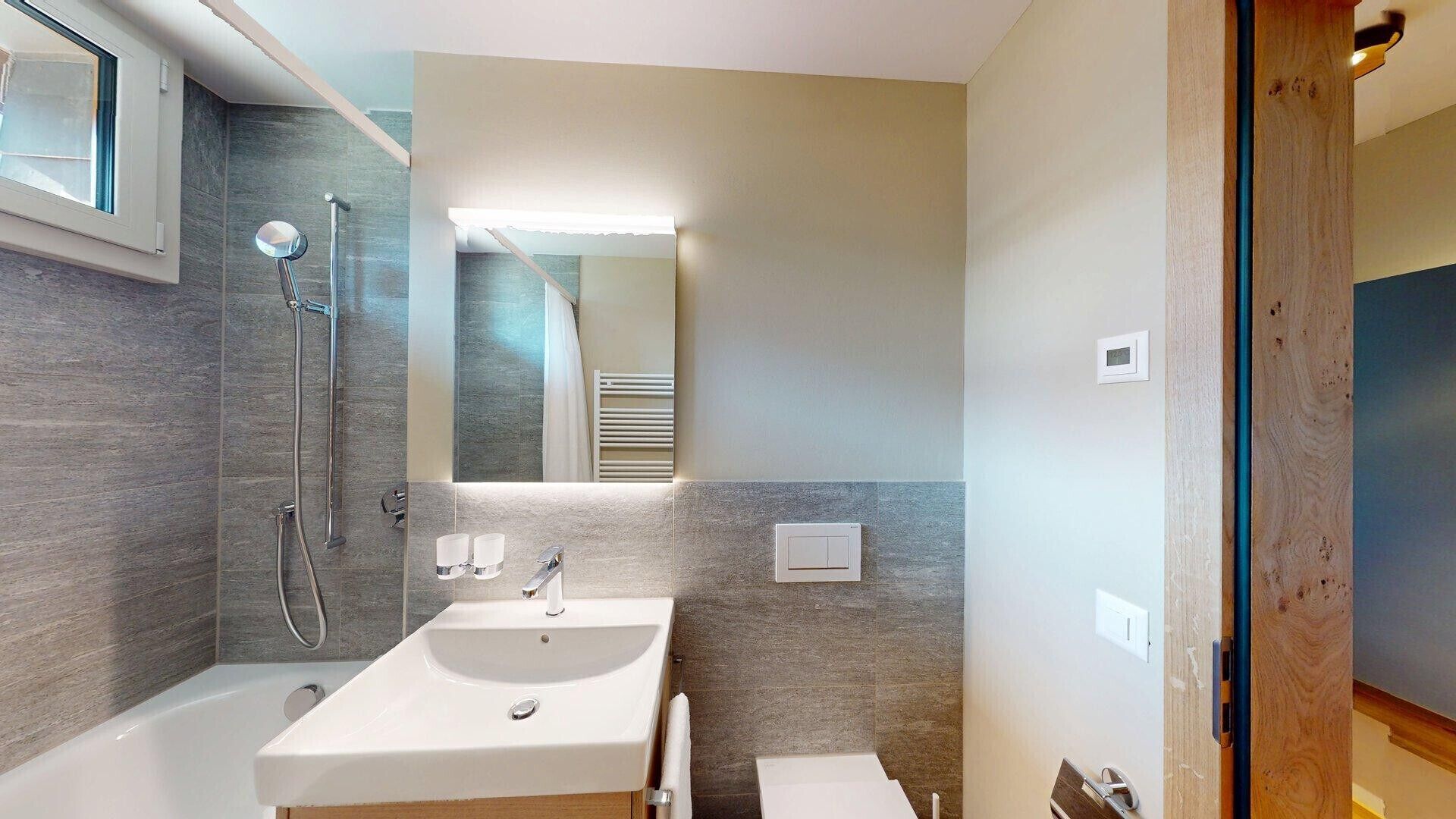 Un baño moderno con un lavamanos grande, una ducha y un espejo.