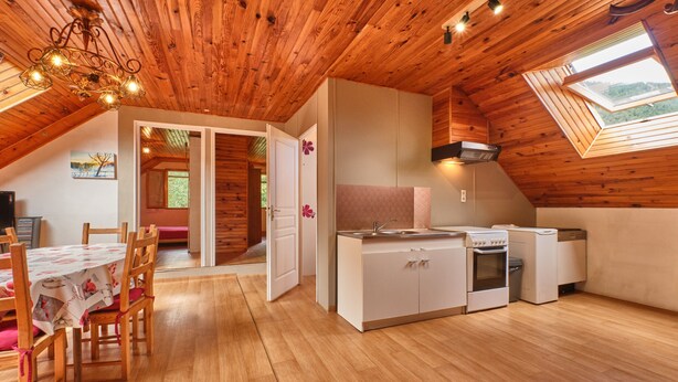 A wooden interior with a dining area, kitchen, and skylight. - Holiday Home 'Des Granges' with Mountain Views, Private Terrace & Wi-Fi (Tréminis)