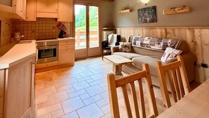 Un interior de madera con cocina, comedor y sofá.