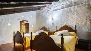 A bedroom with a wooden bed, a nightstand, a wall-mounted lamp, and a window with a view. - Farmhouse 'Moli D'en Pi' with Mountain View, Shared Terrace and Private Garden (Morella)