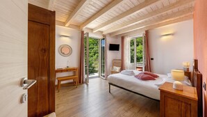 Une chambre à coucher avec un lit, des meubles en bois, un bureau et un téléviseur.