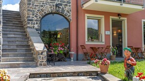 A stone staircase leading to a building with a large arched entrance, outdoor seating, and potted plants. - Room 'Cottarze' with Mountain View, Wi-Fi and Air Conditioning (Unknown)