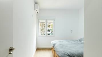 Une chambre à coucher avec un lit, une fenêtre et une porte.
